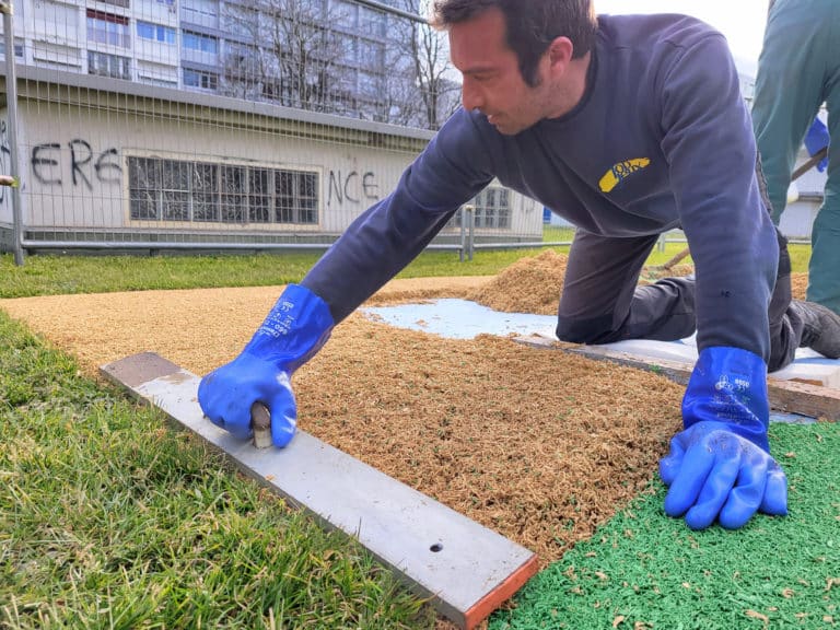 Photo d'un homme qui fait une surface amortissante pour une aire de jeux